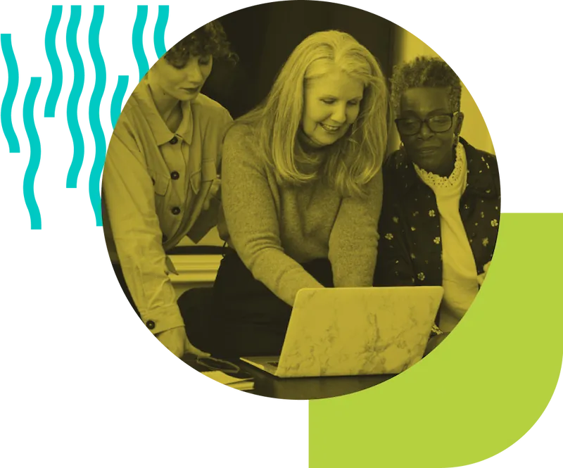 Three ladies watching a computer screen together.
